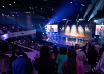 Believers pray during a worship service at the "Royal Cite" evangelical mega-church, which belongs to the "Impact Centre Chretien" international evangelic network, in Croissy-Beaubourg, east of Paris, on April 28, 2024.