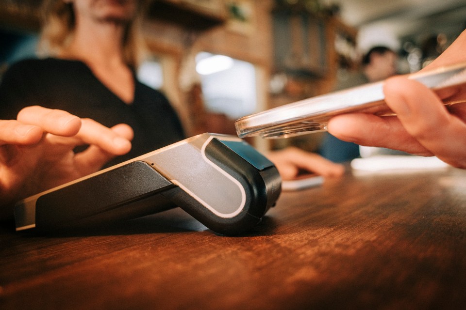 Customer paying with a smartphone on a credit card reader.