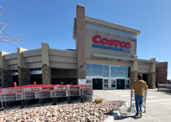 A lone shopper pushes a cart toward the entrance of a Costco warehouse on March 13, 2025, in Sheridan, Colorado.