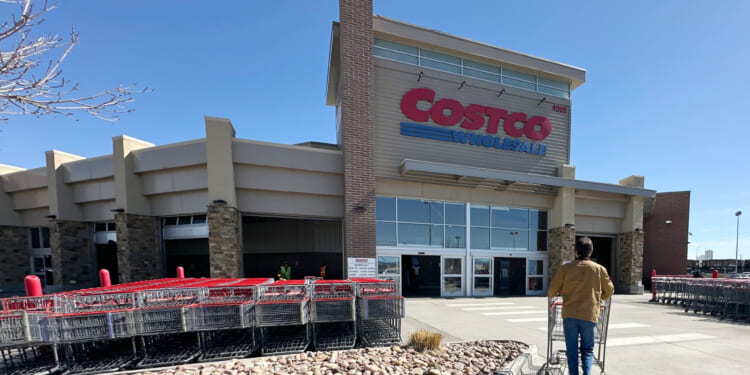 A lone shopper pushes a cart toward the entrance of a Costco warehouse on March 13, 2025, in Sheridan, Colorado.