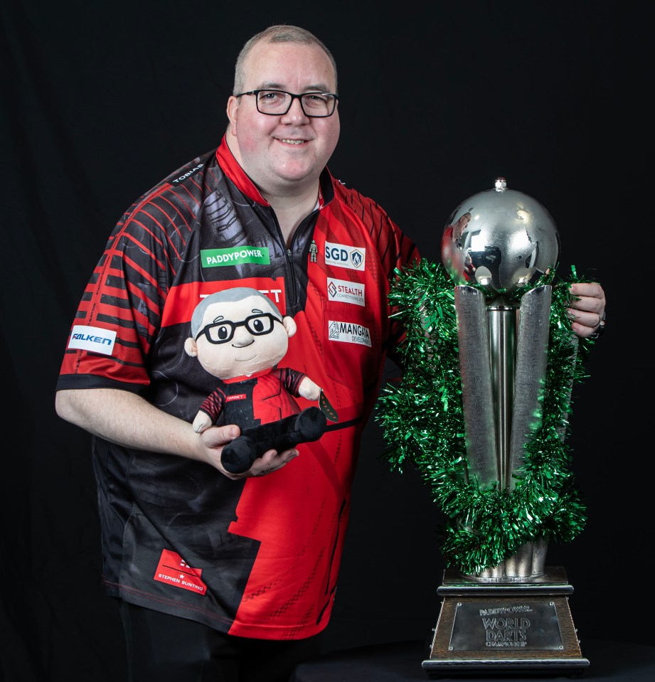 Stephen Bunting holding a trophy and a plush toy of himself.