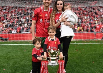 Jota is pictured at Anfield with the Premier League trophy alongside his partner, Rute Cardoso, and their three children after helping Liverpool secure their 20th league title last season