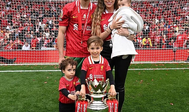 Jota is pictured at Anfield with the Premier League trophy alongside his partner, Rute Cardoso, and their three children after helping Liverpool secure their 20th league title last season