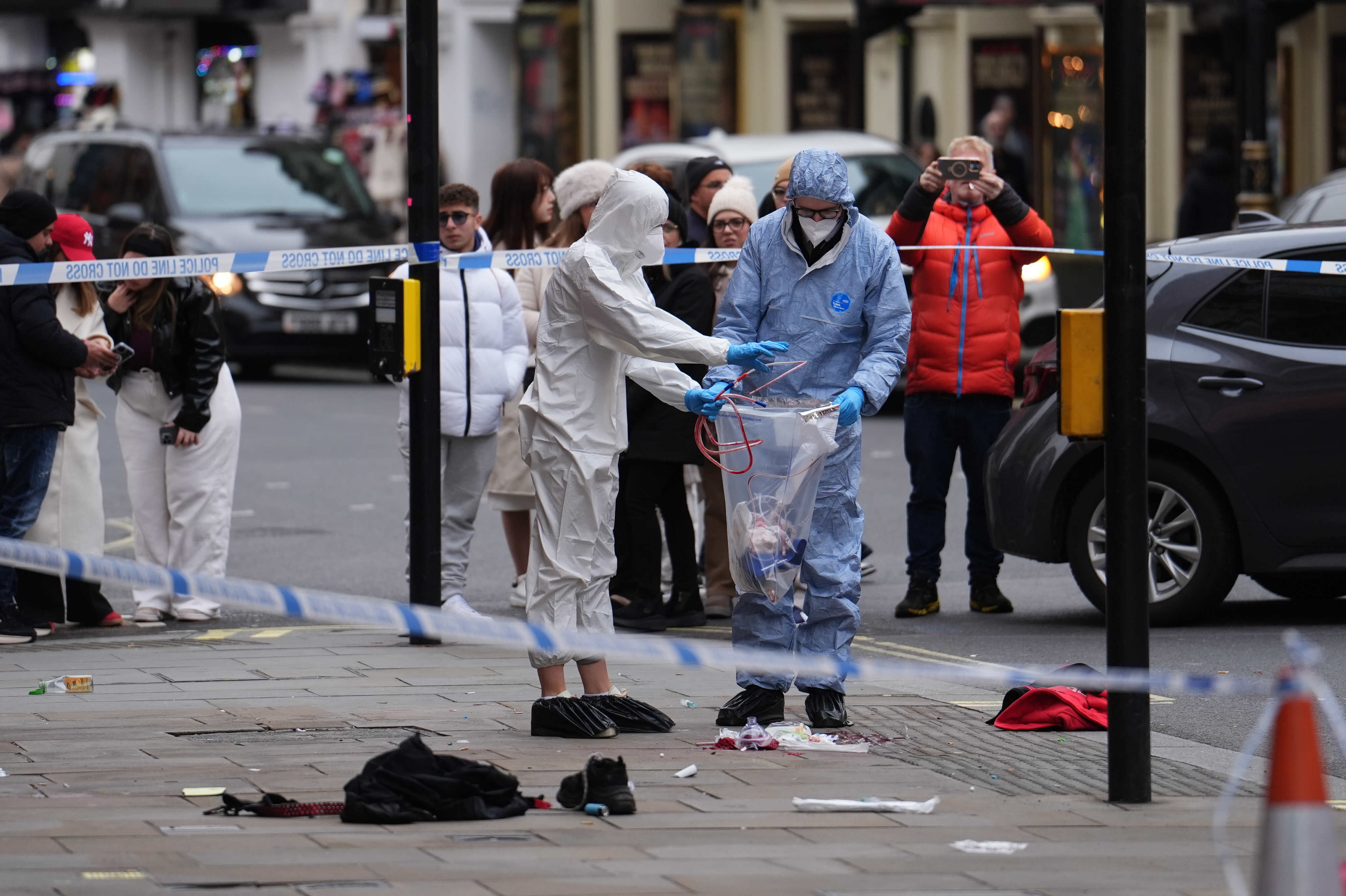 Forensic investigators collecting evidence at the scene on Shaftesbury Avenue in central London.
