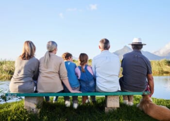A family looking at a scenic view while sitting together in a nature reserve.
