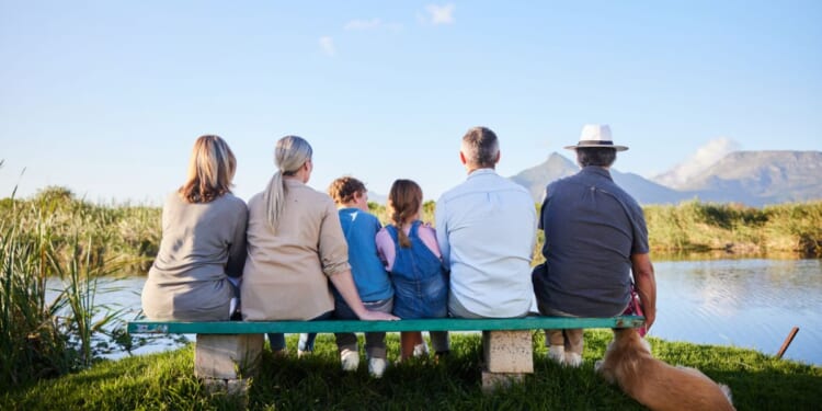 A family looking at a scenic view while sitting together in a nature reserve.