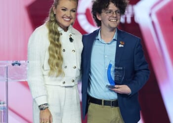 Erika Kirk poses with student Caleb Chilcutt during Turning Point USA's AmericaFest on Saturday