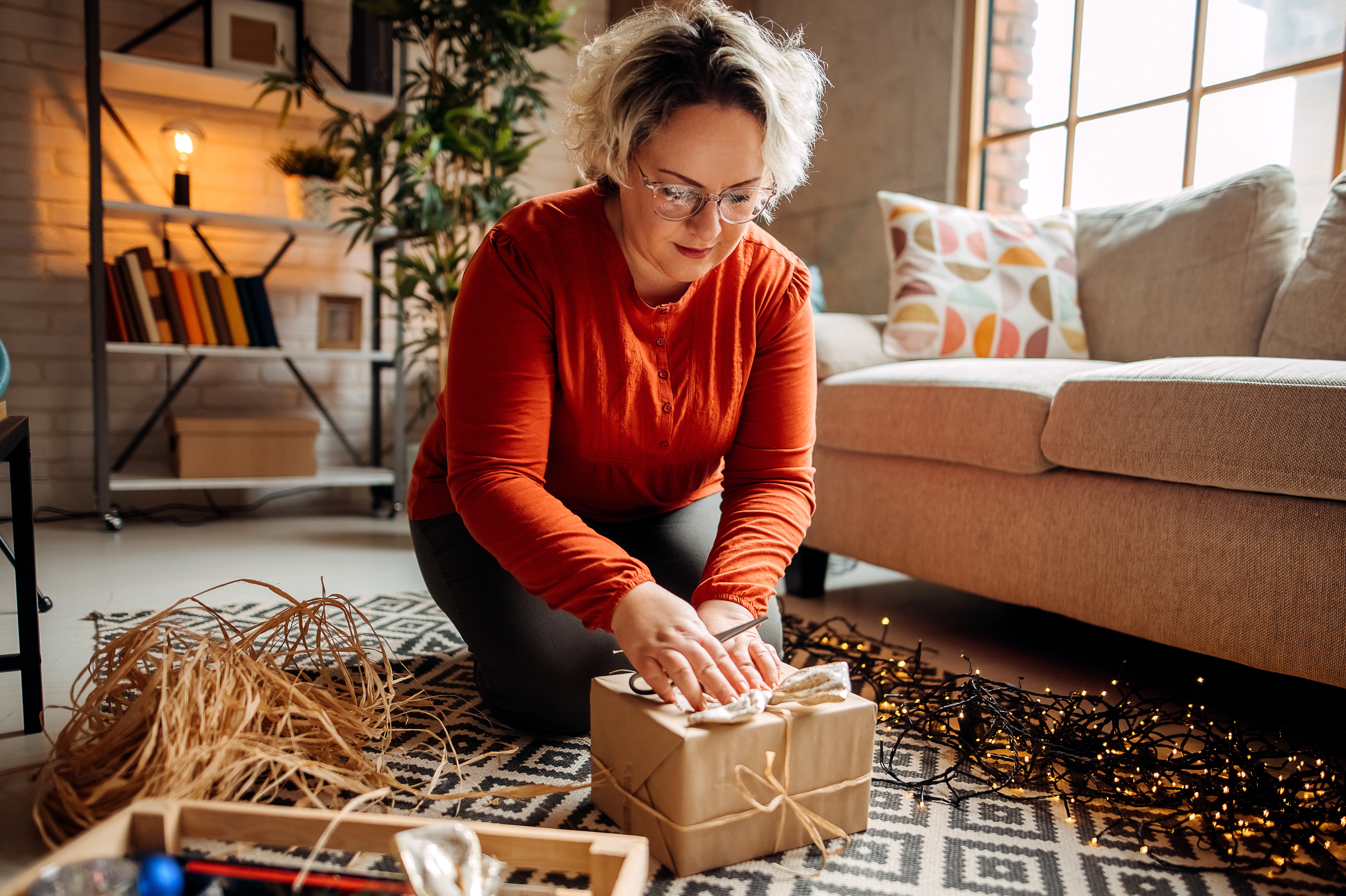 Woman wrapping a Christmas present at home.