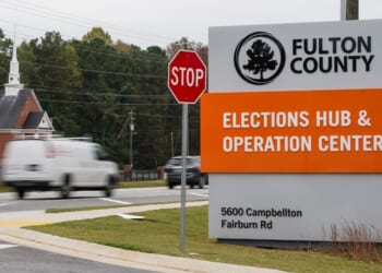 Vehicles pass by the sign for the Fulton County Elections Hub and Operations Center on Nov. 4, 2024, in Union City, Georgia.