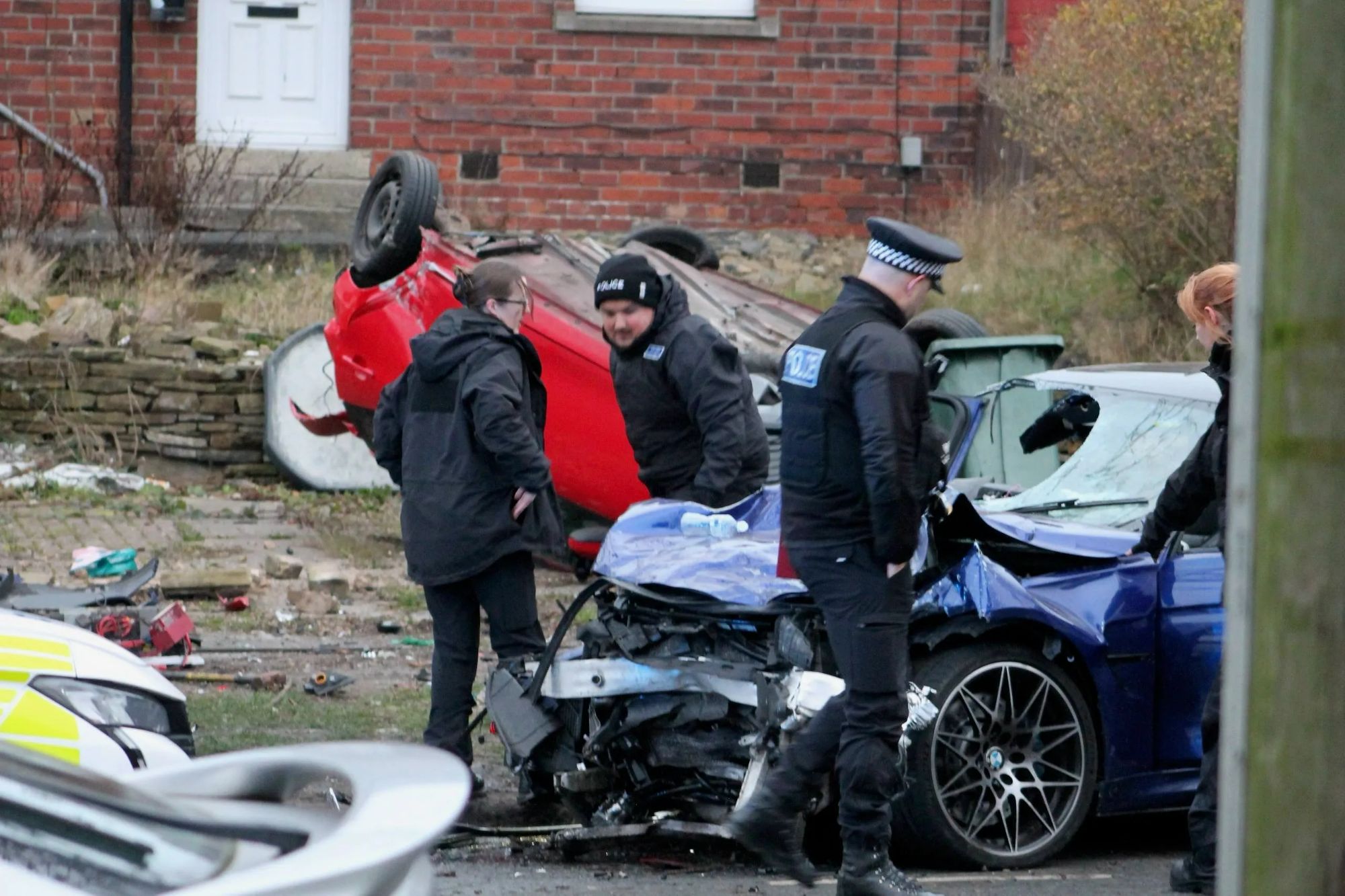 An image collage containing 1 images, Image 1 shows Scene of a high-speed car crash in Bradford with an overturned red car, a damaged blue car, and police officers