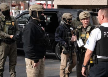 Border Patrol chief Greg Bovino speaks with a Chicago Police officer while searching for undocumented immigrants in a southwest side neighborhood on Nov. 6, 2025, in Chicago, Illinois.