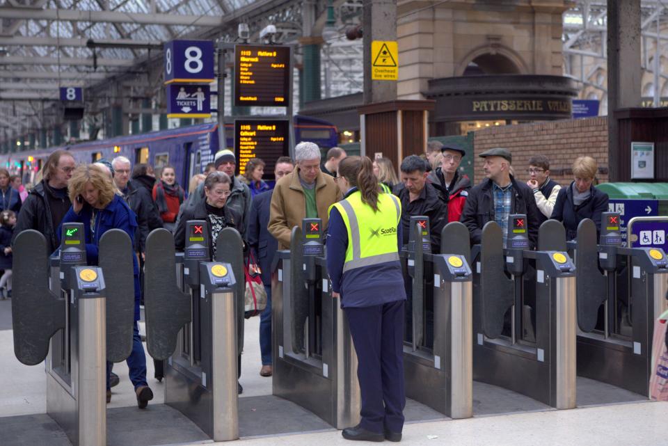 Glasgow central railway station ticket turnstiles during rush hour with queues and train staff collecting tickets scotrail
