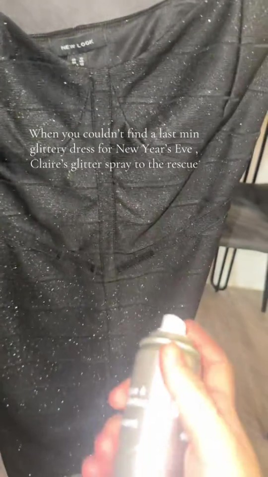 A person spraying a black dress with glitter spray to make it glittery for New Year's Eve.