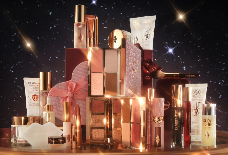 Charlotte Tilbury makeup products and gift sets on a reflective surface with a starry background.