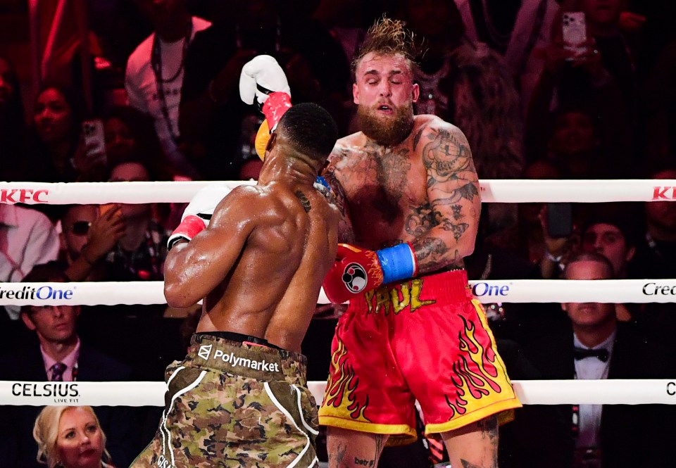 Anthony Joshua throwing a punch at Jake Paul during their heavyweight boxing match.