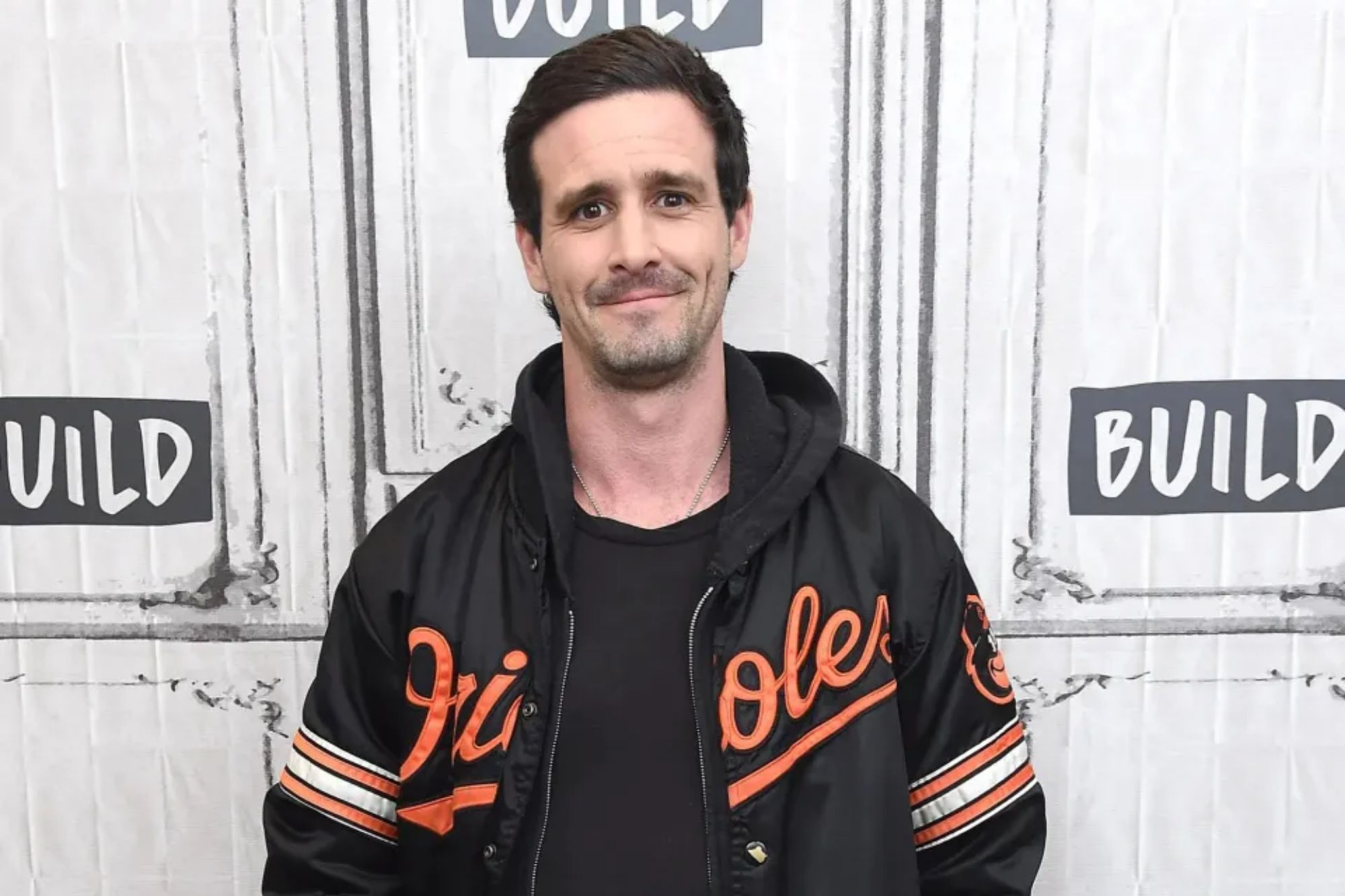 An image collage containing 1 images, Image 1 shows A man wearing a black Orioles jacket