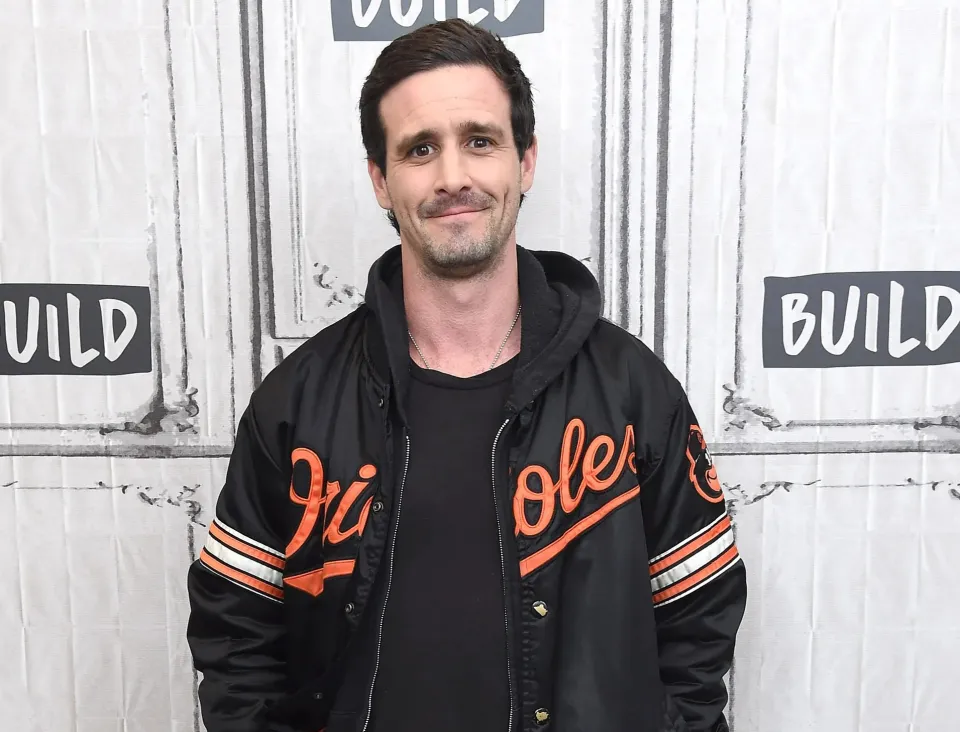 A man wearing a black Orioles jacket.