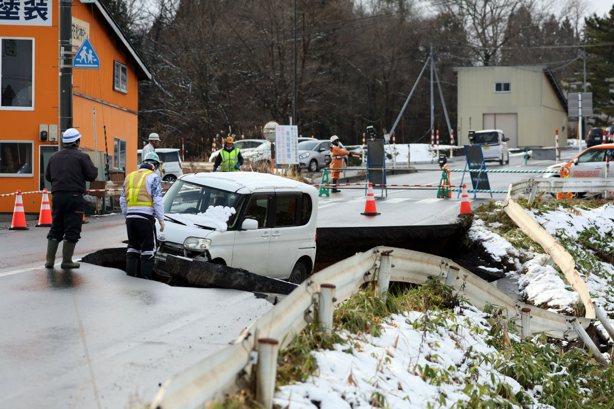 An image collage containing 1 images, Image 1 shows Workers gather at a collapsed road in Tohoku, Aomori prefecture, northeastern Japan