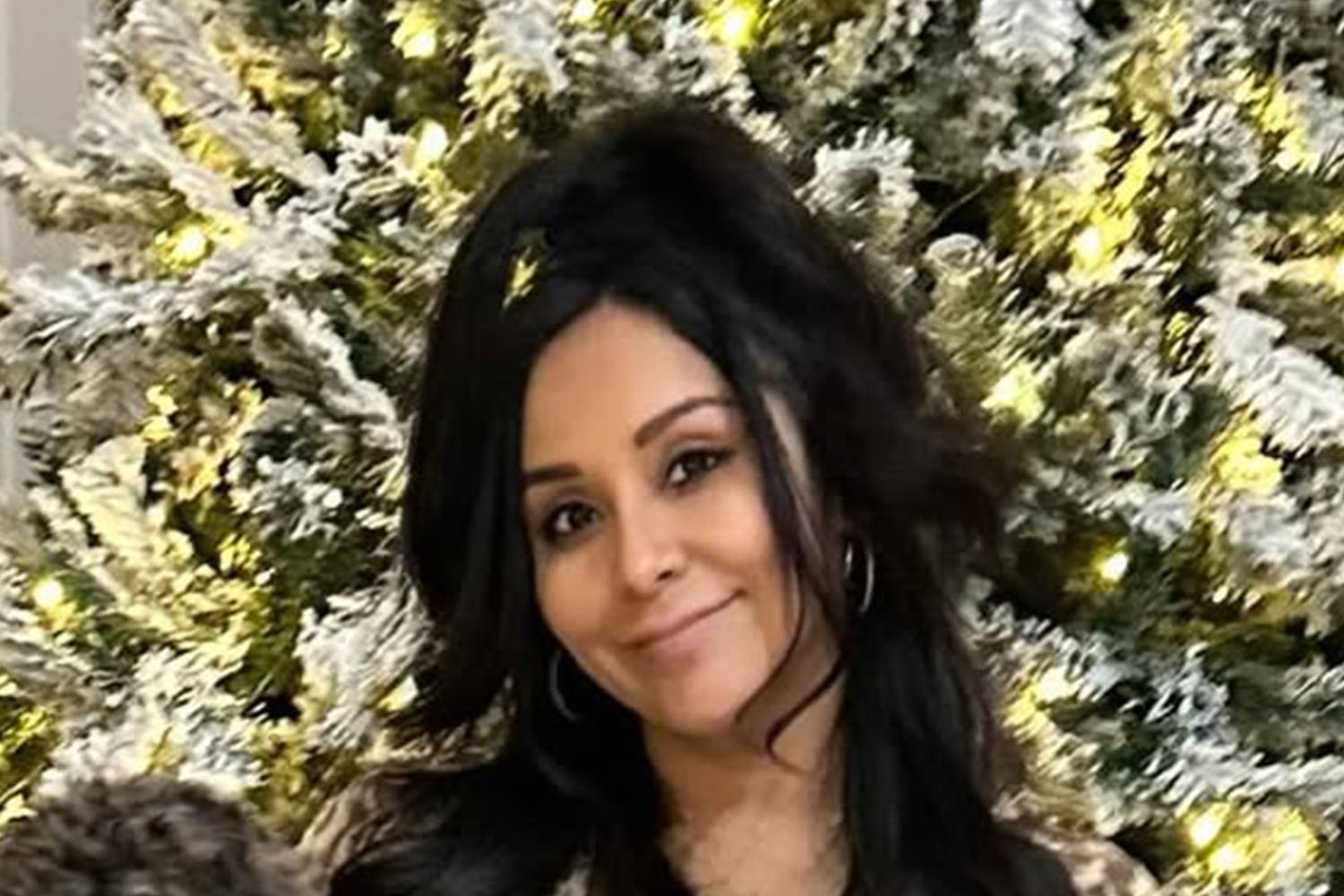 Snooki in front of a Christmas tree.