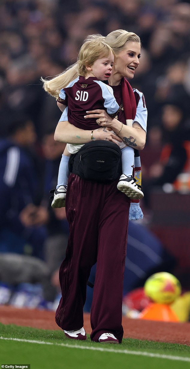 The TV star, dressed in the team's kit, beamed with pride as her three-year-old son Sidney took to the pitch as a mascot