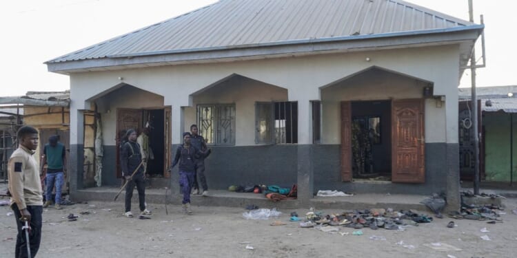 Members of the Civilian Joint Task Force stand at the scene of the explosion at a mosque in the Gamboru market in Maiduguri on Dec. 25, 2025.
