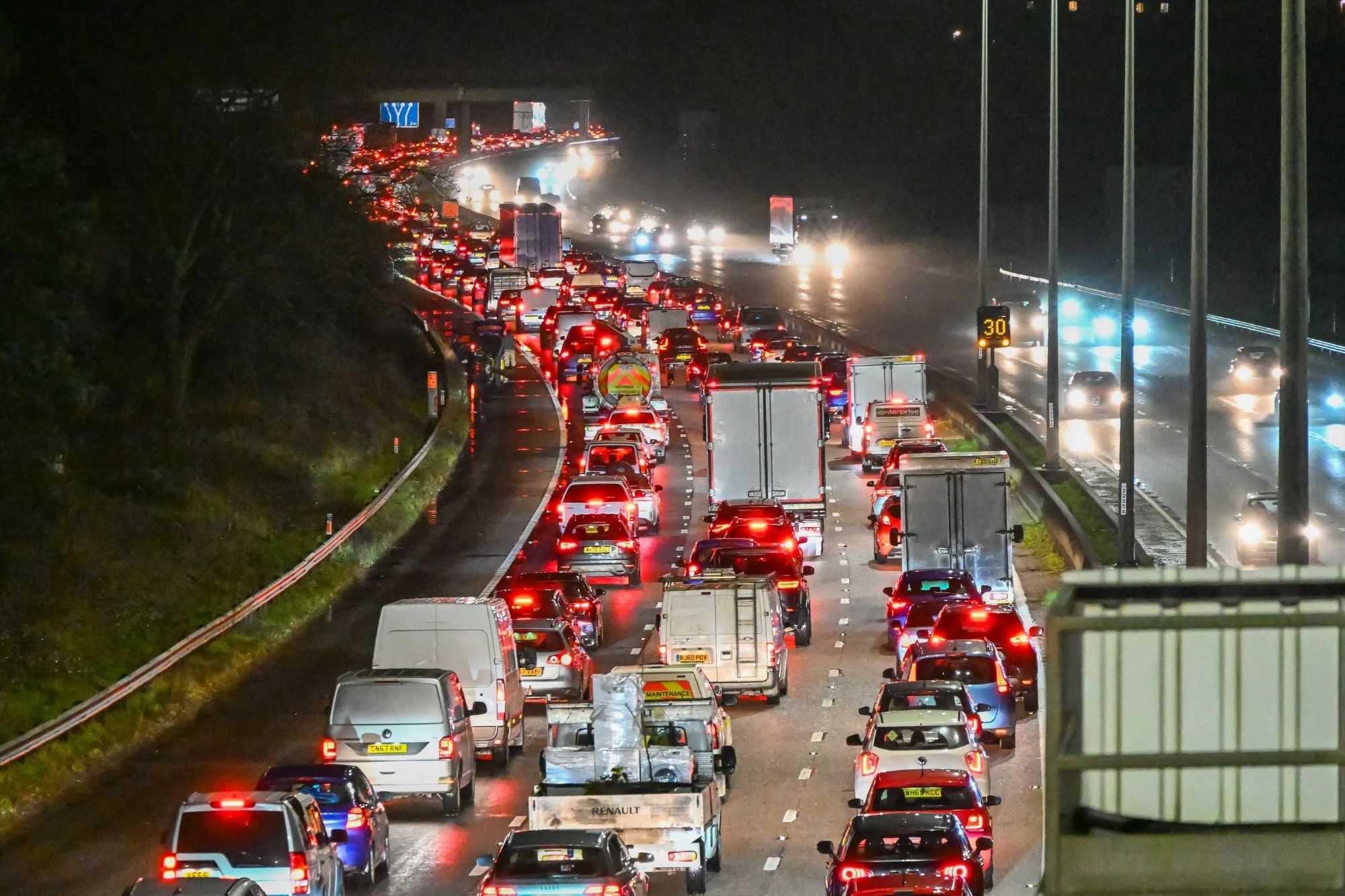 An image collage containing 1 images, Image 1 shows Night-time view of traffic almost at a standstill on the M5 motorway in Exeter