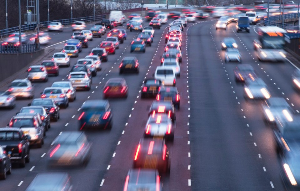 Busy urban motorway at dusk with blurred car lights from traffic.
