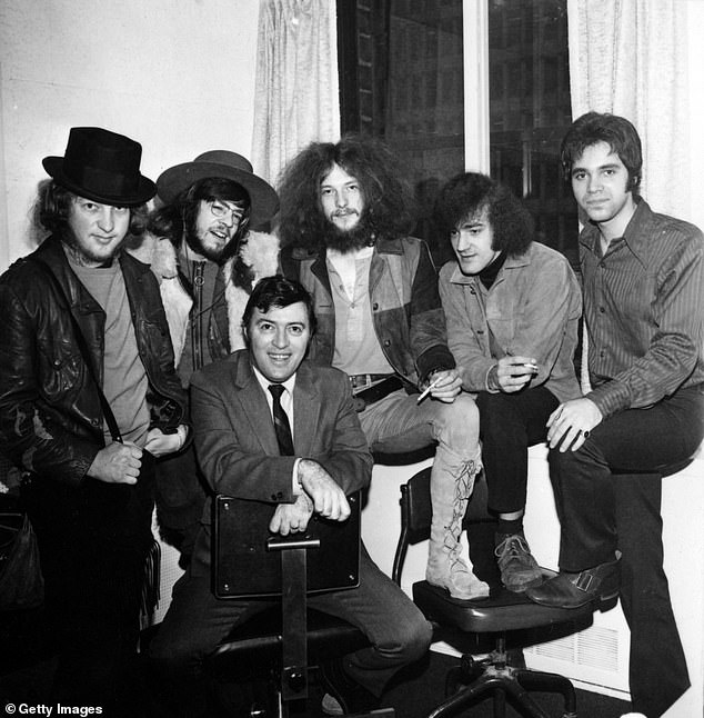 Members of the rock and roll band Jethro Tull pose for a portrait with their album This Was and record label executives in 1968 in New York