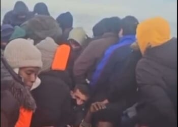 Orange Nike trainers are passed around the boat by the migrants to get water out of the bottom