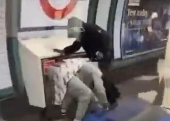 One of the men is on the ground while two youths lay into him on the Tube platform at Colliers Wood, south London