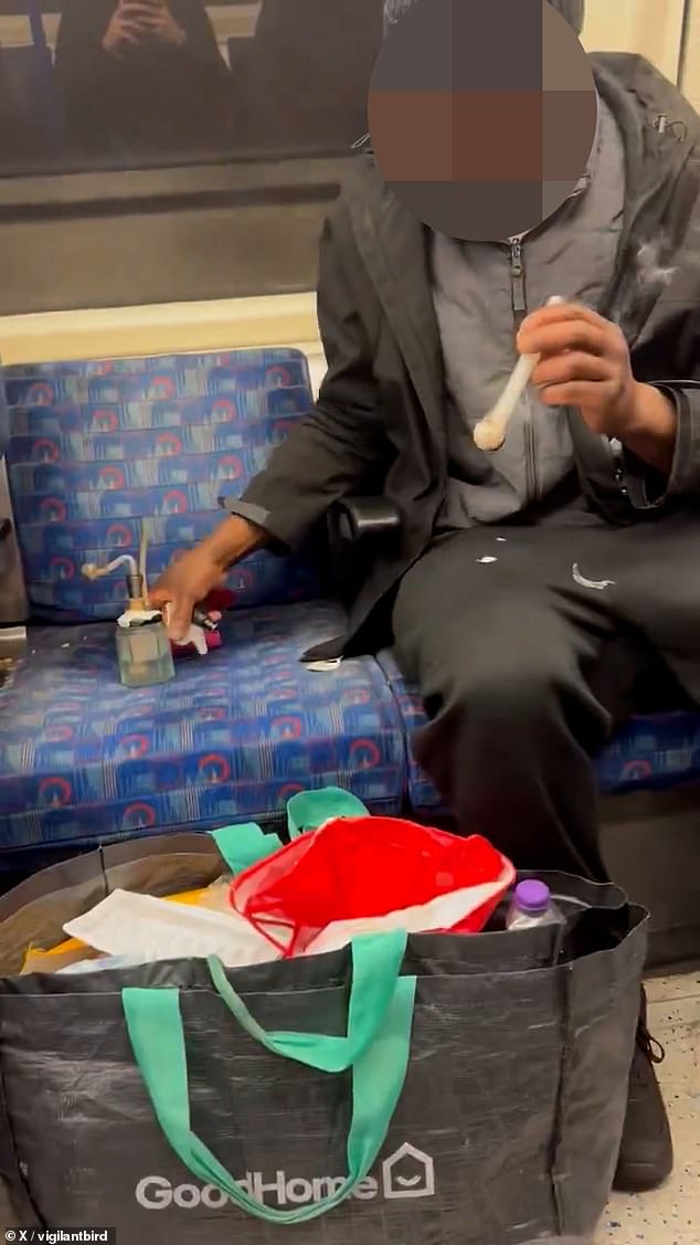Sitting in a 'priority seat', a bearded man was pictured in April inhaling from his DIY bong and is engulfed in drug fumes as children walk past