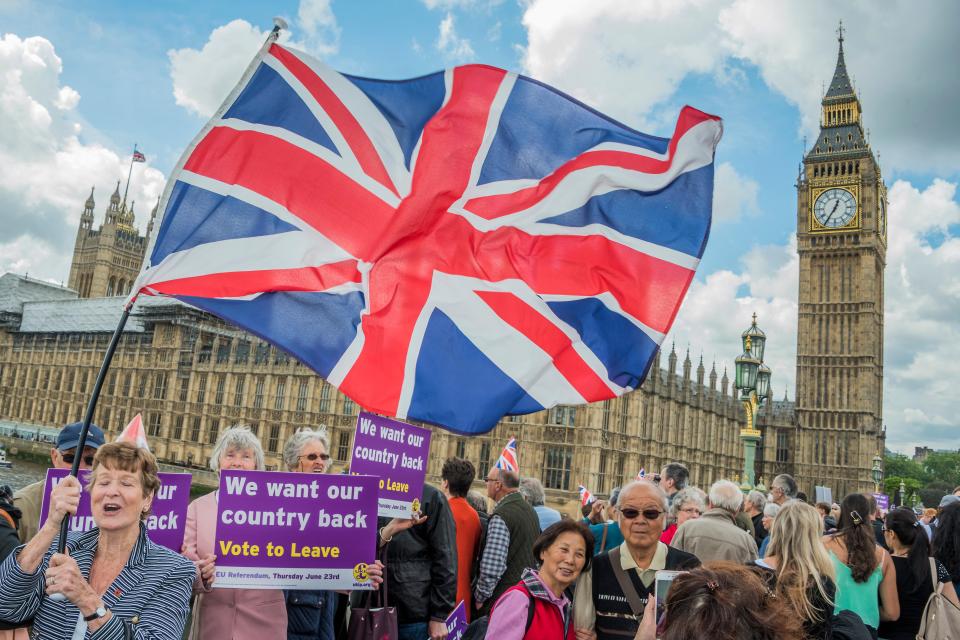 Leave supporters on Westminster Bridge, with a large Union Jack flag, holding "Vote to Leave" signs.