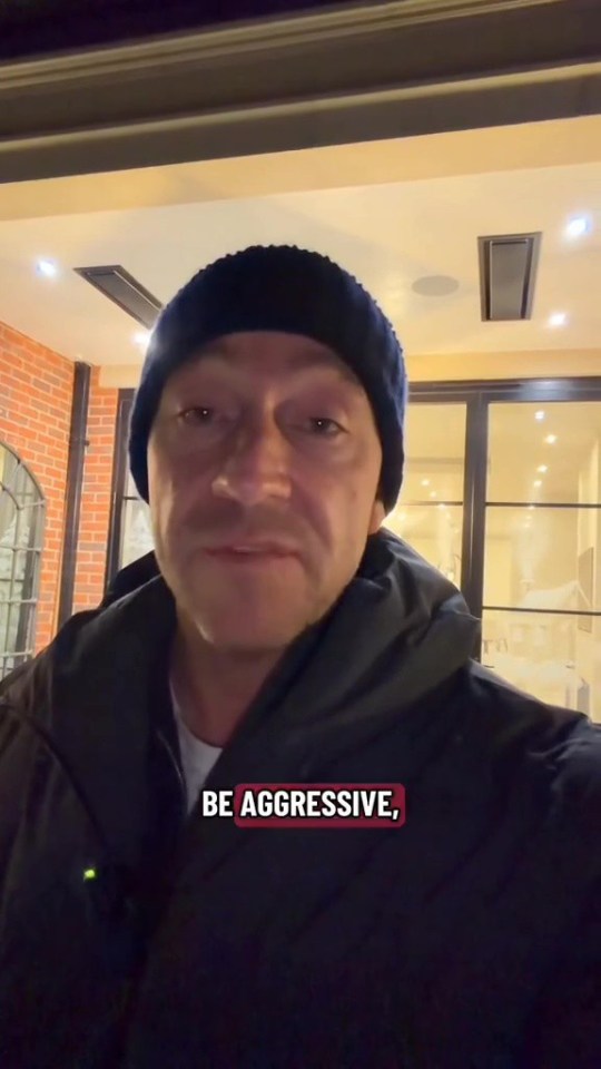 A man in a black beanie and jacket with the words "BE AGGRESSIVE," overlaid on the bottom right.