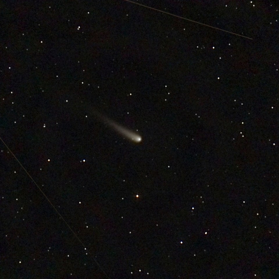Comet C/2023 A3 (ATLAS-Tsuchinshan) in a dark sky filled with stars.