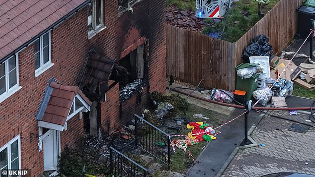 Another child and an adult remain in hospital after the house fire in Ashford, Kent on Sunday (Pictured: Deflated Christmas decorations in the front garden of the home)