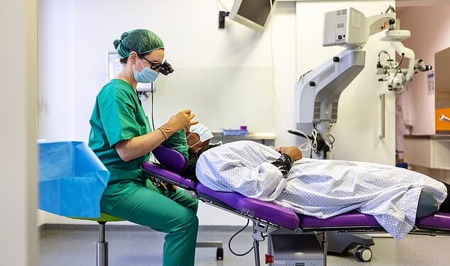 Side view of a doctor examining patient's eye during surgery