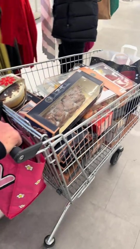 A shopping cart filled with various boxed items.
