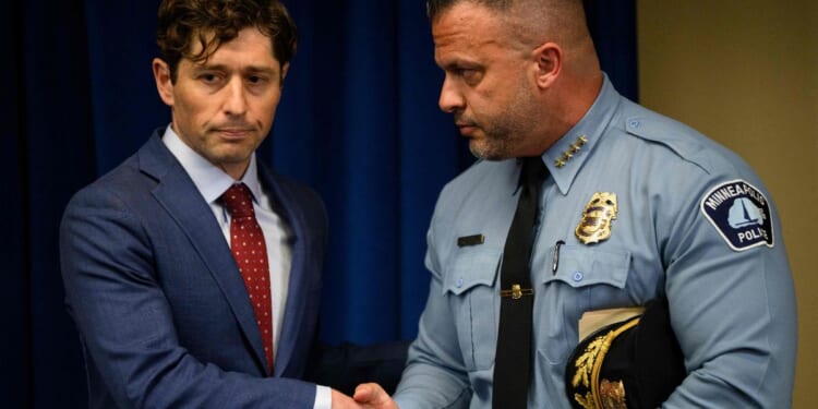 Minneapolis Police Chief Brian O'Hara shakes hands with Minneapolis Mayor Jacob Frey after he addressed the findings of a Justice Department investigation into the Minneapolis Police Department during a press conference in Minneapolis, Minnesota, on June 16, 2023.
