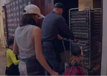 A new glimpse of Archie (left in yellow) and Lilibet (right in tartan) as they push a trolley of food for the poor on Thanksgiving in a Happy Holidays video