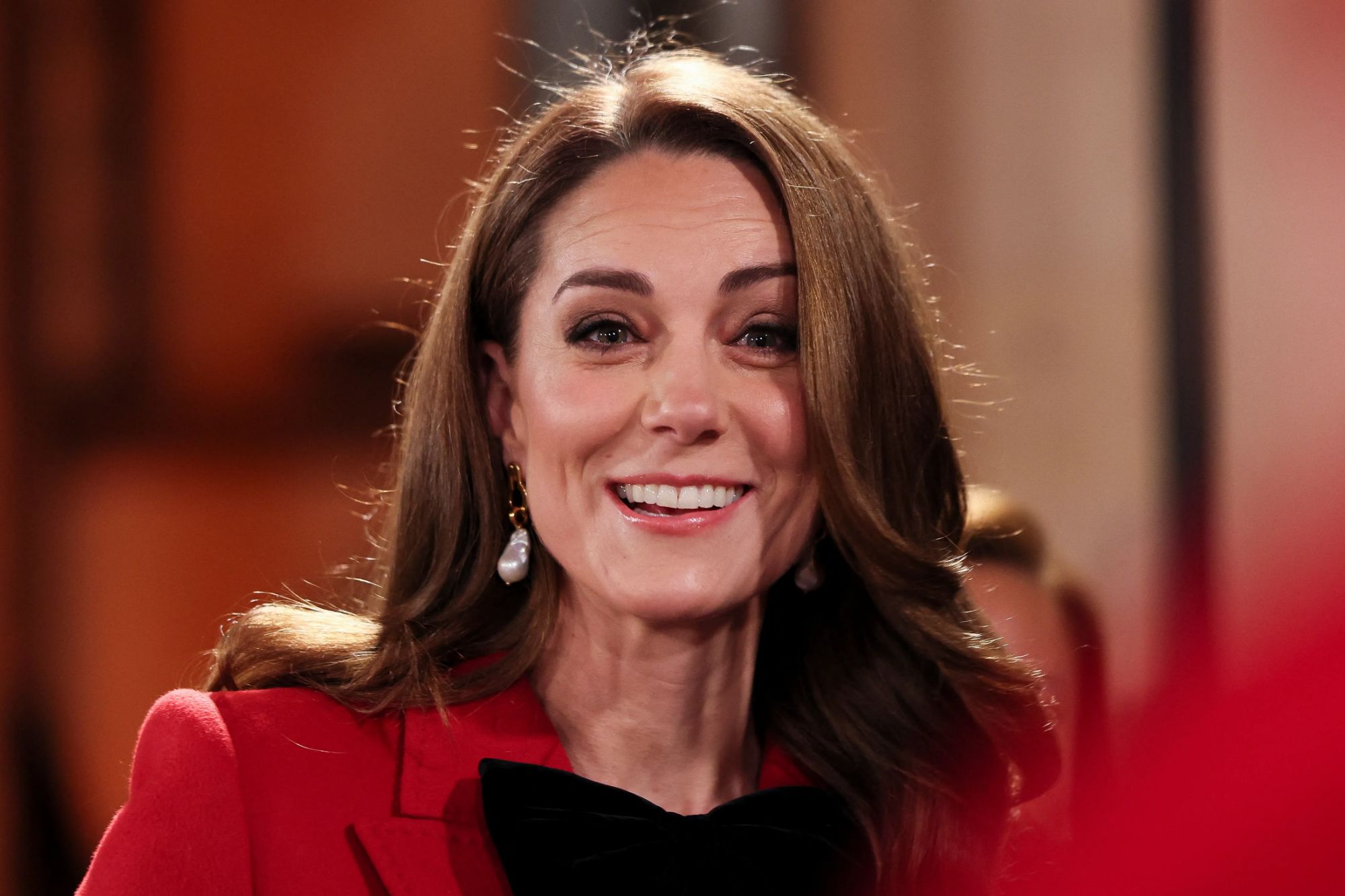 An image collage containing 1 images, Image 1 shows The Princess of Wales, wearing a red coat and black bow, smiling