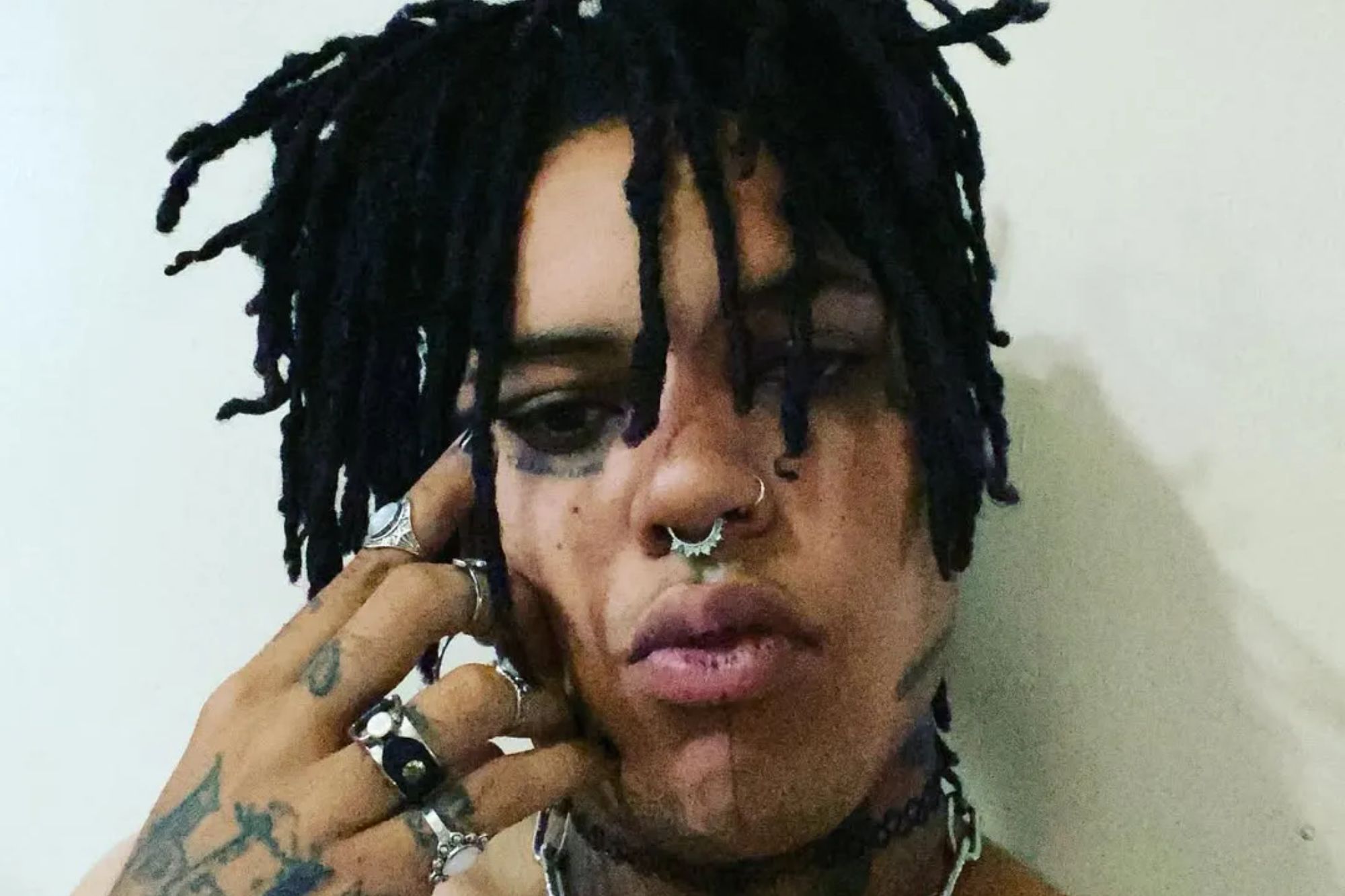 An image collage containing 1 images, Image 1 shows POORSTACY looking at the camera with dark eye makeup and a septum piercing