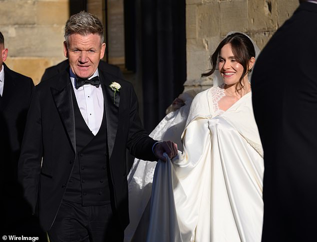 Holly Ramsay with her father, Gordon. Her dress was covered by a bizarre lace-edged white satin shroud which, thanks to the wind, made her look like she’d got tangled up in a bedsheet