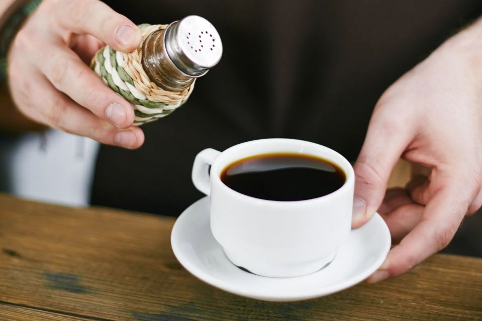 An image collage containing 1 images, Image 1 shows Barista adding salt to black coffee
