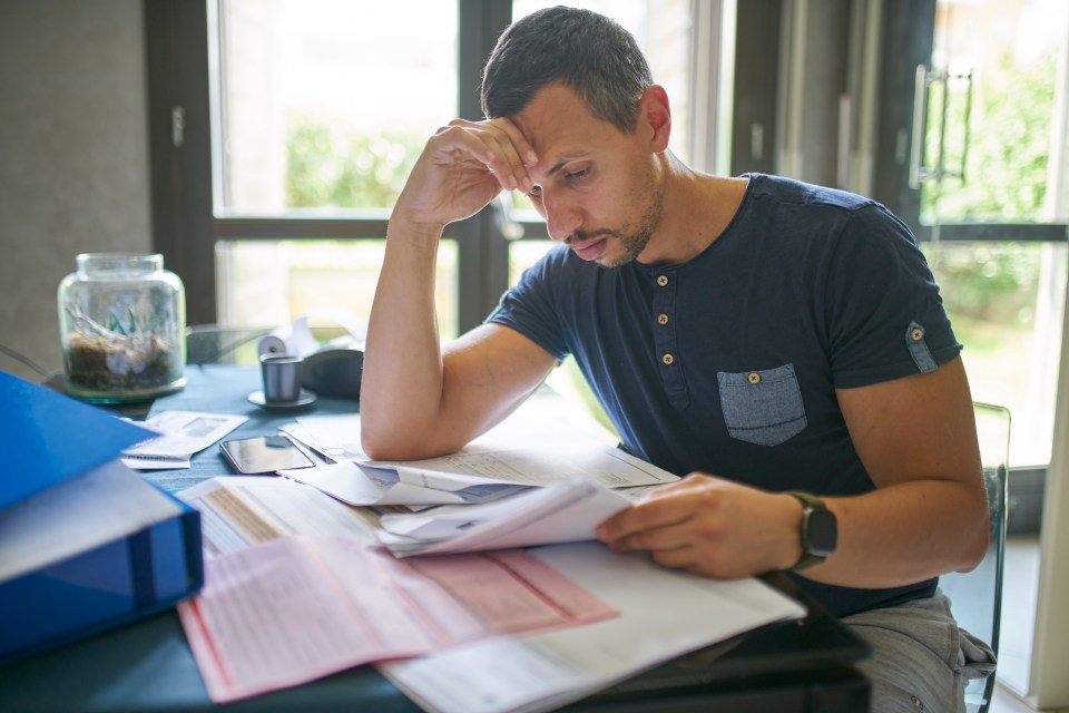Man looking worried while calculating home finances.