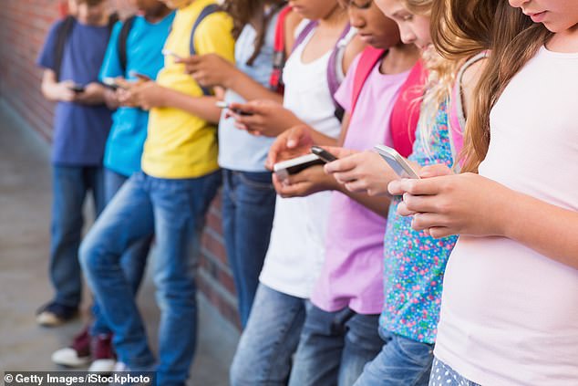 Recent research has revealed that the average teenager spends 11 hours a day on screens, while 55 percent of children aged eight to 11 own a smartphone (stock image)