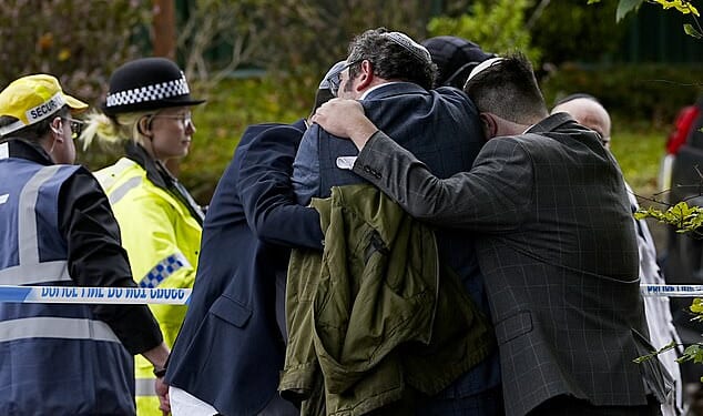 Members of the Jewish community comfort each other outside the Heaton Park Hebrew Congregation synagogue. In the wake of the October terror attack, the government will provide an extra £10million to guarantee the safety of the Jewish community