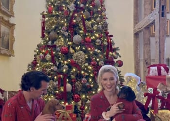 Leonora Smee sits beside her Christmas tree flanked by a mountain of presents with her husband Mark Cosgrove-Smith