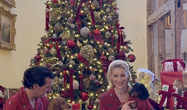 Leonora Smee sits beside her Christmas tree flanked by a mountain of presents with her husband Mark Cosgrove-Smith