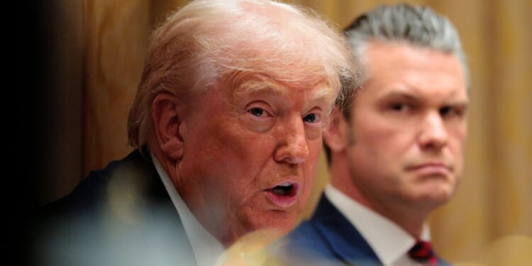 U.S. Secretary of War Pete Hegseth, right, looks on as President Donald Trump speaks during a meeting of his Cabinet Dec, 2 at the White House in Washington, D.C.
