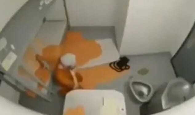 The grainy, 12-second clip appeared to show a man wearing orange prison gear on the floor of his cell